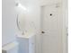 Bright white bathroom featuring a vanity, mirror, and a door with brass hardware at 1974 Hidden Springs Pl, Clearwater, FL 33760