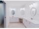 Bright bathroom featuring double sinks, round mirrors, and white countertops at 1974 Hidden Springs Pl, Clearwater, FL 33760