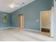 Spacious bedroom with tile floors, high ceilings, blue walls, and doorways to other rooms at 1974 Hidden Springs Pl, Clearwater, FL 33760