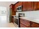 A modern kitchen features stainless steel appliances, wooden cabinets, and light countertops at 1974 Hidden Springs Pl, Clearwater, FL 33760