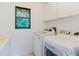 Laundry room featuring a sink, storage, and modern appliances at 1974 Hidden Springs Pl, Clearwater, FL 33760