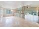 Bright, open living room featuring tile floors, large windows, and sliding glass doors to the outdoor pool area at 1974 Hidden Springs Pl, Clearwater, FL 33760