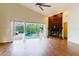 Living area showcasing the fireplace, vaulted ceiling, wood floors, and sliding glass doors to the screened lanai and pool at 1974 Hidden Springs Pl, Clearwater, FL 33760