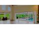 Bright living room featuring high ceilings, wood floors, and access to an outdoor pool area and grilling area at 1974 Hidden Springs Pl, Clearwater, FL 33760