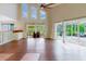 Open-concept living room with hardwood floors, a dry bar, and access to an outdoor dining area and grilling station at 1974 Hidden Springs Pl, Clearwater, FL 33760
