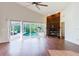 Inviting living room features a stone fireplace, wood floors, and views of the screened-in pool area at 1974 Hidden Springs Pl, Clearwater, FL 33760