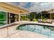 An inviting screened-in pool area offers both relaxation and entertainment spaces with lush greenery surrounding the property at 1974 Hidden Springs Pl, Clearwater, FL 33760