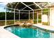 Sparkling in-ground pool with a rock waterfall feature and a screened-in enclosure for year-round enjoyment at 1974 Hidden Springs Pl, Clearwater, FL 33760