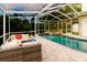 This in-ground pool with patio is screened-in with adjacent outdoor furniture for relaxing and entertaining at 1974 Hidden Springs Pl, Clearwater, FL 33760