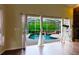 View of screened pool area with waterfall feature and tropical landscape through open glass doors at 1974 Hidden Springs Pl, Clearwater, FL 33760