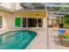 The home's screened-in outdoor pool area features an open layout leading to an outdoor dining and relaxation space at 1974 Hidden Springs Pl, Clearwater, FL 33760