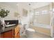 Bright bathroom featuring a tub shower combination, with tile surround and glass block window at 2006 Tanglewood Ne Dr, St Petersburg, FL 33702