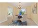 Dining room featuring a chandelier, light walls, and window with a blue and white rug beneath a wood table with four seats at 2006 Tanglewood Ne Dr, St Petersburg, FL 33702