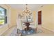 Well-lit dining area features seating for four, neutral walls, and an ornate chandelier with views of the outdoors at 2006 Tanglewood Ne Dr, St Petersburg, FL 33702
