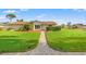 Charming single-story home featuring lush green lawn, mature landscaping, and welcoming front entrance at 2006 Tanglewood Ne Dr, St Petersburg, FL 33702