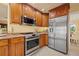 Well-lit kitchen featuring stainless steel appliances and wood cabinets at 2006 Tanglewood Ne Dr, St Petersburg, FL 33702