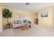 A light-filled living room with yellow walls, neutral carpet flooring and access to other rooms in the house at 2006 Tanglewood Ne Dr, St Petersburg, FL 33702