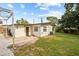 View of the backyard featuring green grass, a small patio, and the back exterior of the home at 2112 Ranchita Trl, Holiday, FL 34690