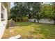 Spacious backyard with mature trees and lawn area, partially enclosed by fencing at 2112 Ranchita Trl, Holiday, FL 34690