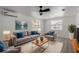 This staged living room has luxury flooring, neutral paint, ceiling fan, and modern furnishings at 2112 Ranchita Trl, Holiday, FL 34690