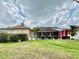 Large backyard showcasing the home's exterior, screened lanai, landscaping, and green lawn at 23112 Emerson Way, Land O Lakes, FL 34639