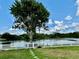 Expansive backyard with lush green lawn, leading to a serene pond, bordered by a white fence at 23112 Emerson Way, Land O Lakes, FL 34639