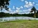 Picture perfect backyard featuring a large pond and white picket fence for privacy and scenic views at 23112 Emerson Way, Land O Lakes, FL 34639