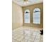 Bright bedroom featuring tile floors and two arched windows at 23112 Emerson Way, Land O Lakes, FL 34639