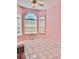 Bedroom with tile flooring, arched windows, and pink walls at 23112 Emerson Way, Land O Lakes, FL 34639