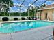 Sparkling in-ground pool with screened enclosure, offering a serene view of lush landscaping at 23112 Emerson Way, Land O Lakes, FL 34639
