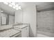Granite vanity in the bathroom is accompanied by new tile in the shower and a large mirror at 2581 Countryside Blvd # 2309, Clearwater, FL 33761