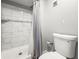 Bathroom includes a shower and toilet with grey walls and white fixtures at 2581 Countryside Blvd # 2309, Clearwater, FL 33761