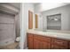 Bathroom with wood cabinets, a light countertop, a large mirror and shower with tile at 2581 Countryside Blvd # 2309, Clearwater, FL 33761