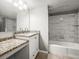 Bathroom featuring a granite vanity, sink, shower and bath, complemented by marble style tile at 2581 Countryside Blvd # 2309, Clearwater, FL 33761