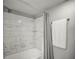 Bathroom features newly tiled shower, grey walls, and new fixtures at 2581 Countryside Blvd # 2309, Clearwater, FL 33761