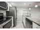 Bright kitchen featuring stainless steel appliances, granite countertops, and white cabinets at 2581 Countryside Blvd # 2309, Clearwater, FL 33761