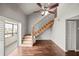 Well-lit living room with hardwood floors, fan, wooden staircase, and balcony access at 2581 Countryside Blvd # 2309, Clearwater, FL 33761