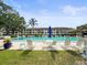 Community pool with lounge chairs, mature trees, and a building in the background at 2581 Countryside Blvd # 2309, Clearwater, FL 33761
