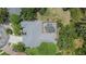 Aerial view of a home with a screened in pool and well-manicured landscaping at 27440 Cedar Park Ct, Wesley Chapel, FL 33544
