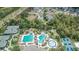 Aerial view showcases community amenities: pools, tennis courts, and lush landscaping at 27440 Cedar Park Ct, Wesley Chapel, FL 33544