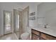 Bathroom features a tiled shower with glass door, wood vanity, and natural light from the window at 27440 Cedar Park Ct, Wesley Chapel, FL 33544