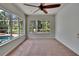 Bedroom features a ceiling fan and multiple windows overlooking the pool and backyard at 27440 Cedar Park Ct, Wesley Chapel, FL 33544