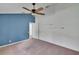 Spacious bedroom featuring blue accent wall, with carpet flooring and three display shelves at 27440 Cedar Park Ct, Wesley Chapel, FL 33544