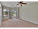 Bedroom featuring a ceiling fan, neutral walls, carpet flooring, and access to an outdoor space at 27440 Cedar Park Ct, Wesley Chapel, FL 33544