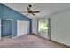 Spacious bedroom featuring blue accent wall, with carpet flooring and ample natural light at 27440 Cedar Park Ct, Wesley Chapel, FL 33544