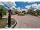 Community gate featuring brick columns, landscaping, and access to a secure neighborhood at 27440 Cedar Park Ct, Wesley Chapel, FL 33544
