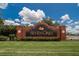 The Seven Oaks brick community entrance sign with a manicured lawn and blue sky at 27440 Cedar Park Ct, Wesley Chapel, FL 33544
