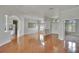 Open-concept living room with hardwood floors and arched entryways, great for entertaining at 27440 Cedar Park Ct, Wesley Chapel, FL 33544
