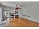 Open living room features hardwood flooring, a ceiling fan, fireplace and built-in shelving at 27440 Cedar Park Ct, Wesley Chapel, FL 33544
