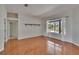 Bright living room offers hardwood floors, a large window, and neutral paint palette at 27440 Cedar Park Ct, Wesley Chapel, FL 33544